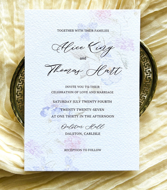 Wedding invitation card with soft, watercolour floral design on textured paper
