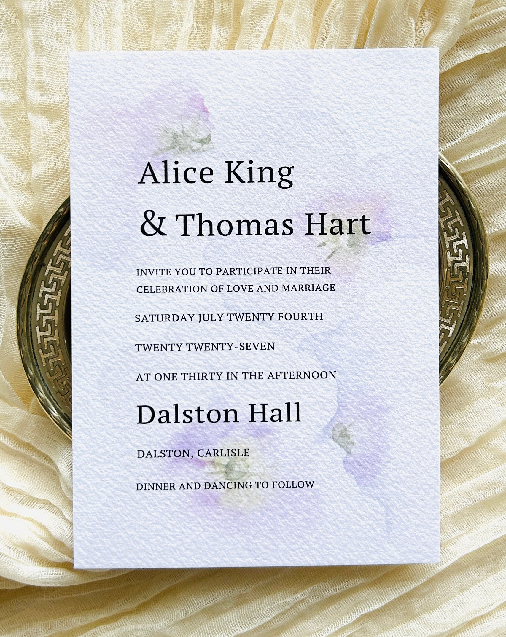 Wedding invitation card with a soft, watercolour floral decoration and a modern font
