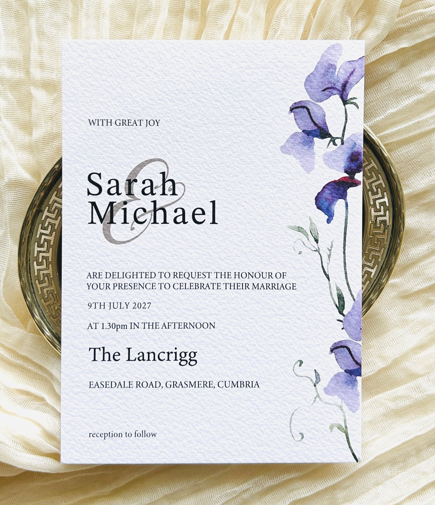 Wedding invitation card with a purple floral design 
