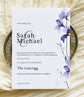 Wedding invitation card with a purple floral design 
