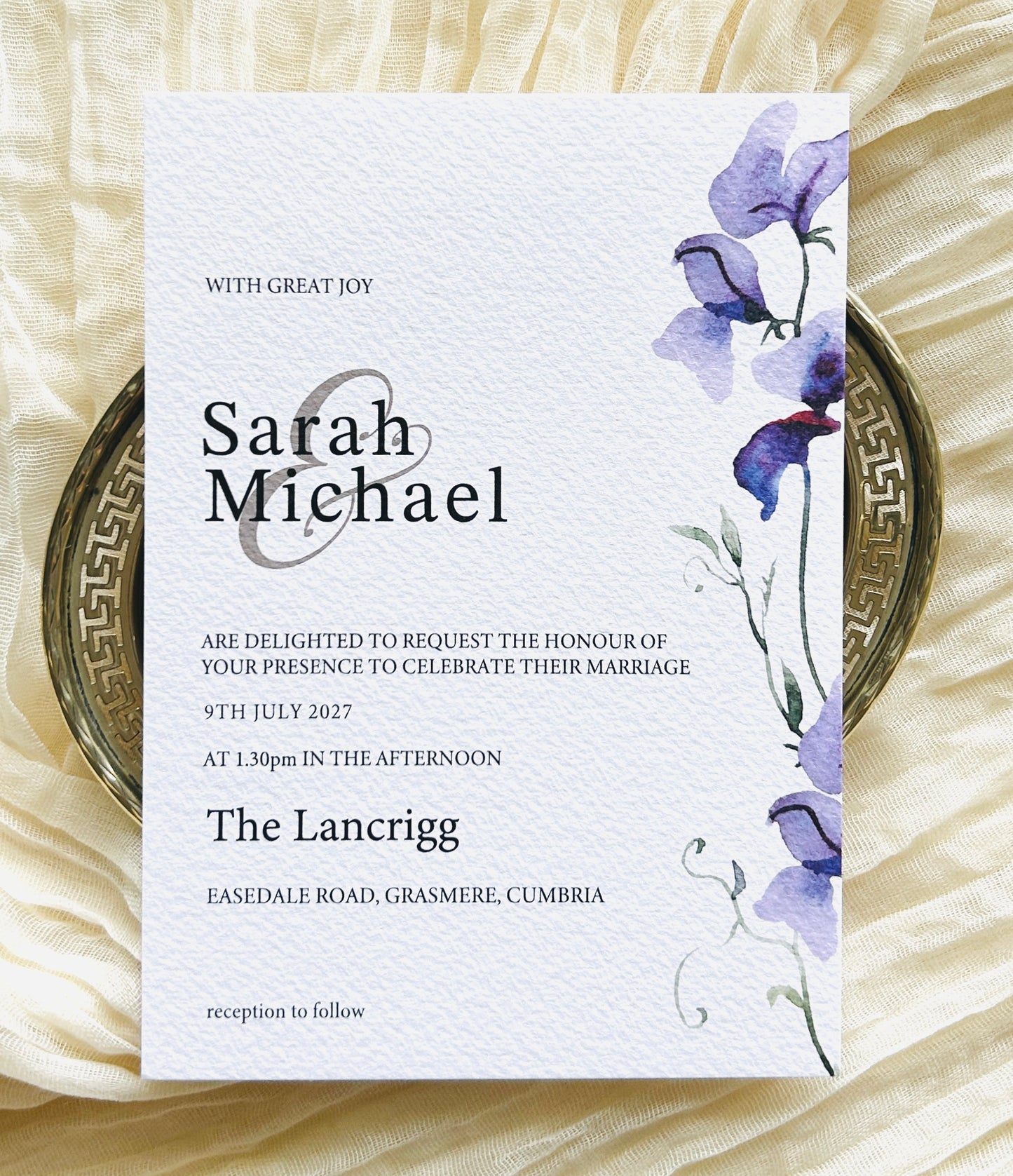 Wedding invitation card with a purple floral design 
