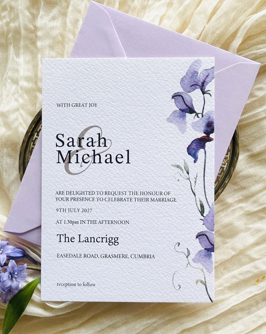 Wedding invitation card with a purple floral design and lilac envelope
