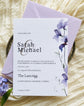 Wedding invitation card with a purple floral design and lilac envelope
