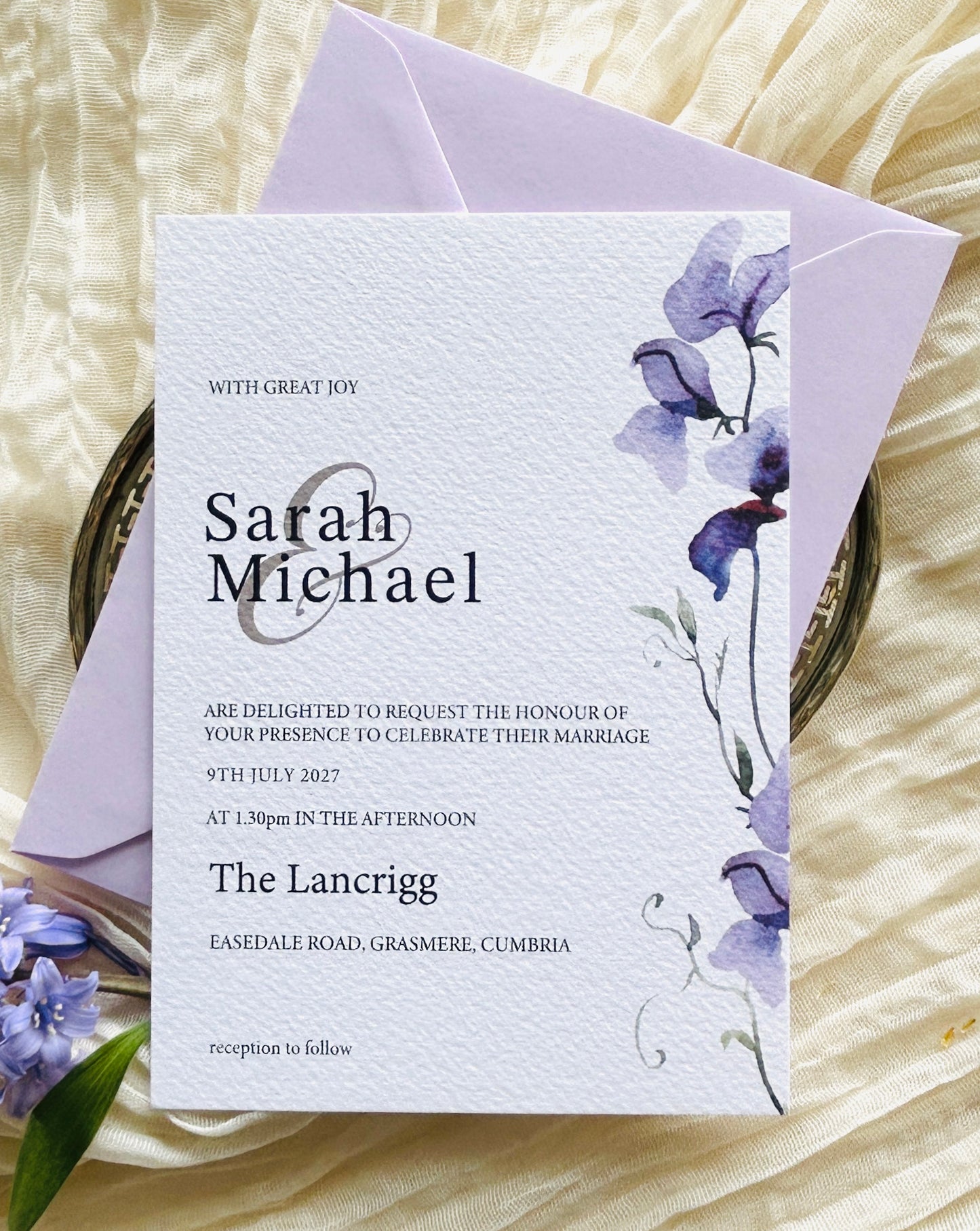 Wedding invitation card with a purple floral design and lilac envelope
