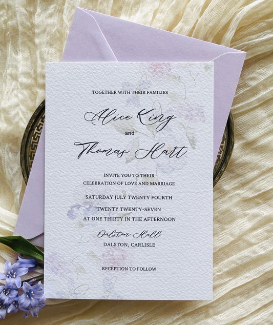 Wedding invitation card with a soft, watercolour floral design and a lilac envelope 
